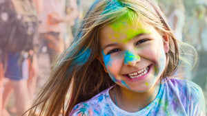 A girl at a Day Camp in Canada with colour powder on her.