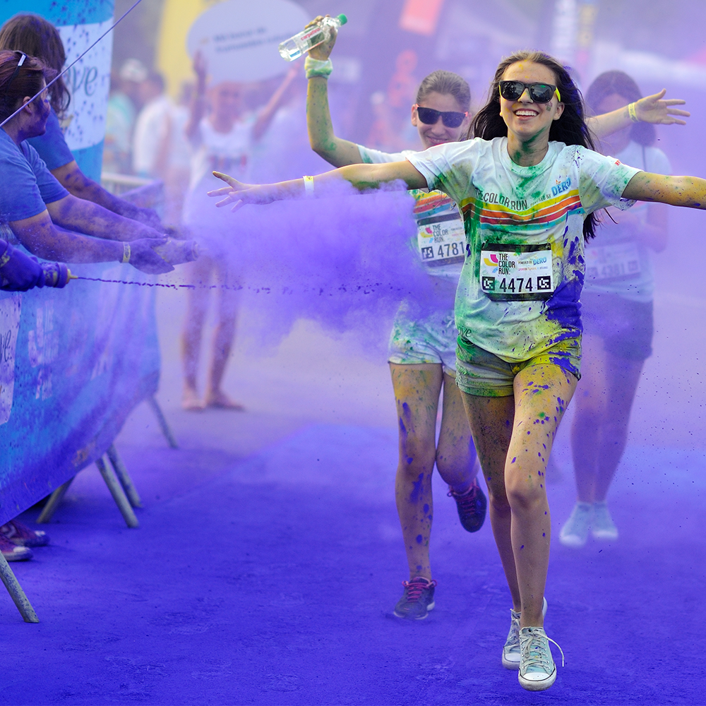 Girls running through Colour powder