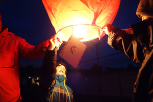 people launching a christmas lantern